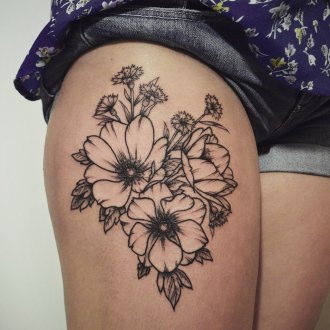 Женская татуировка цветы на бедре