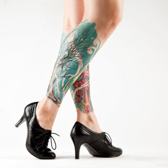 Женская татуировка дерево и сакура на ногах